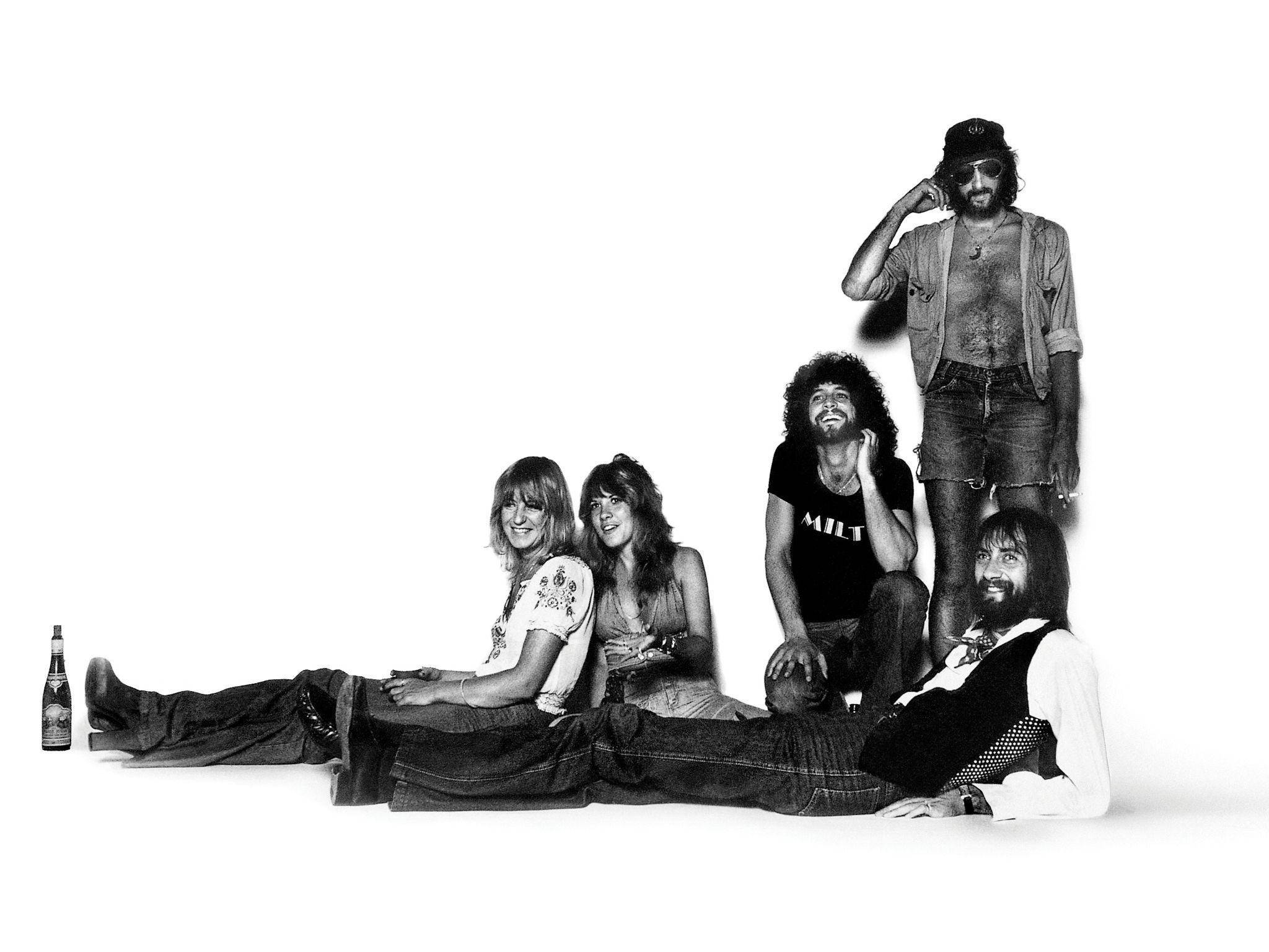 band 桌布 壁紙 — 五名身穿1970年代搖滾風格的男子在純白背景前隨意擺姿勢，旁邊放著一個啤酒瓶。