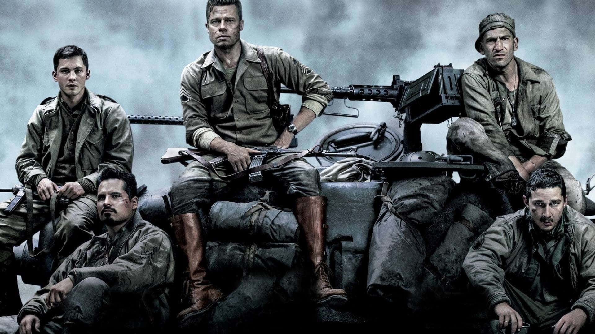 1920x1080 HD Movie 桌布 壁紙 — 五名身穿泥濘制服、疲憊的士兵坐在坦克上，在暴風雨般的灰色天空下持步槍。