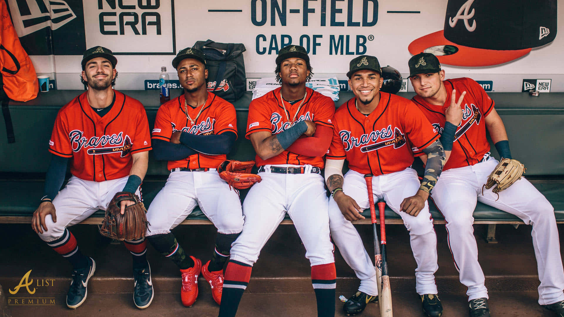 Atlanta Braves Desktop 桌布 壁紙 — 五名身穿紅色球衣的亞特蘭大勇士隊棒球選手，自信地坐在球員休息區的長椅上，手持球棒和手套。