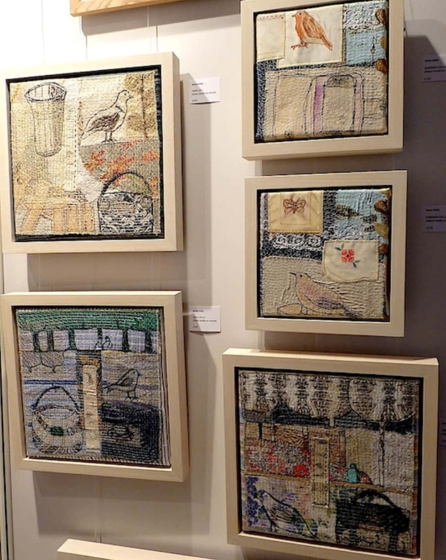 Textile Art 桌布 壁紙 — 五幅帶有刺繡鳥類和家庭場景的裱框紡織藝術品掛在畫廊牆上。
