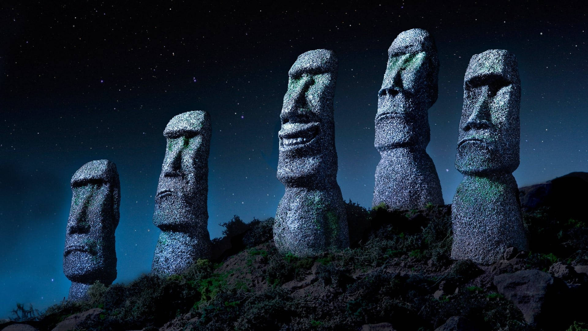 Chile 桌布 壁紙 — 五座古老的石像摩艾雕像在星空夜空下，在岩石山丘上莊嚴地矗立，周圍散發著藍色光芒。