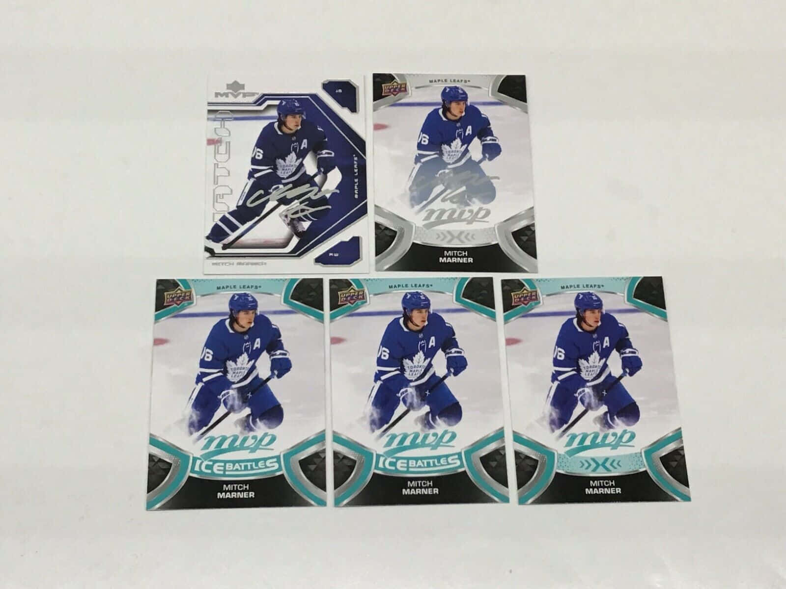Cards 桌布 壁紙 — 五張 Mitch Marner 身穿多倫多楓葉隊裝備的冰球交易卡排列在純白色表面上。