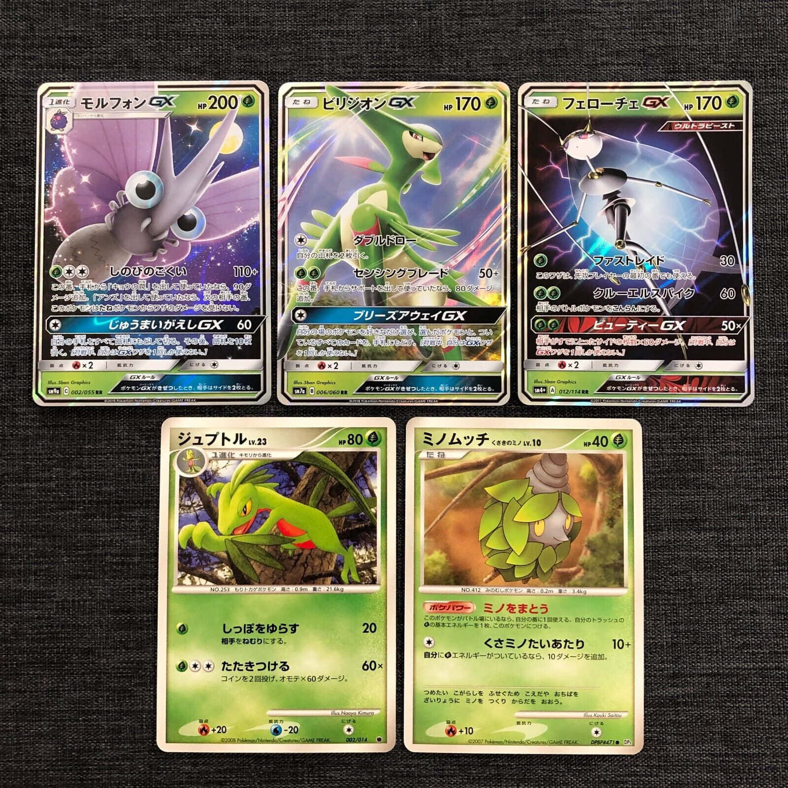 任天堂 桌布 壁紙 — 五張色彩繽紛的寶可夢集換式卡牌，包含Morfion GX、Virizion GX、Ferrothorn GX、Jumpluff和Minun，排列在深色紋理布料背景上。