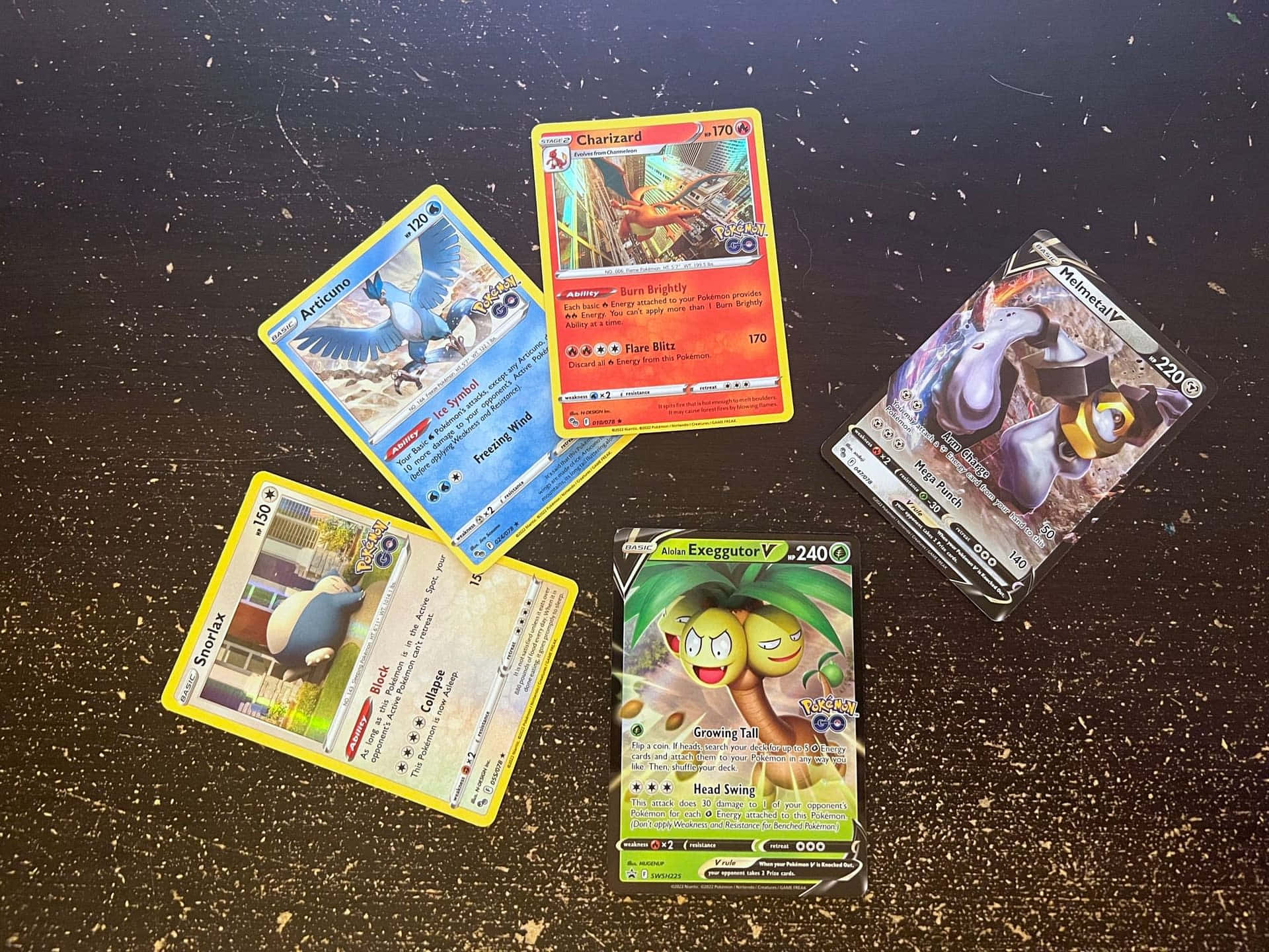 Cards 桌布 壁紙 — 五張色彩繽紛的寶可夢集換式卡牌散落在深色斑點表面上，展示各種寶可夢和數值。