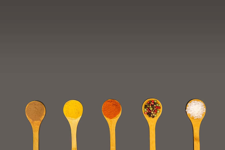 Utensils 桌布 壁紙 — 五把木匙盛載著色彩鮮豔的香料和鹽，背景為深灰色漸變。