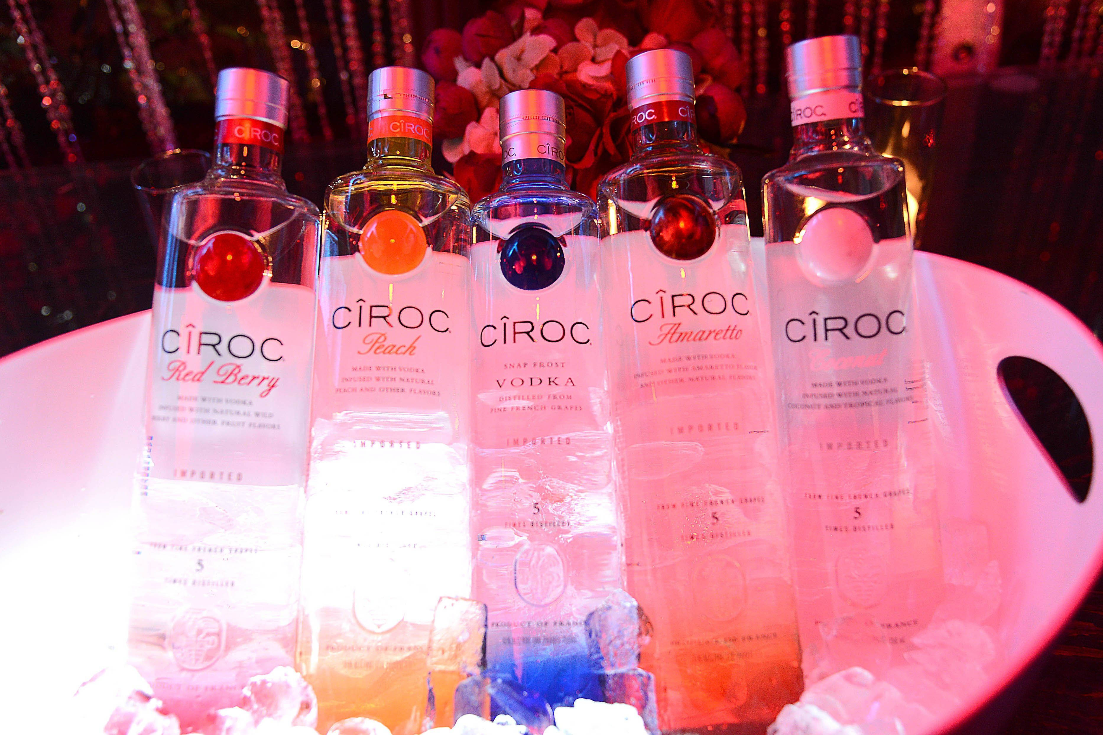 Drink 桌布 壁紙 — 五瓶不同口味的Cîroc伏特加酒，在閃爍的背景中，放在一個發光的粉紅色碗裡冰鎮。