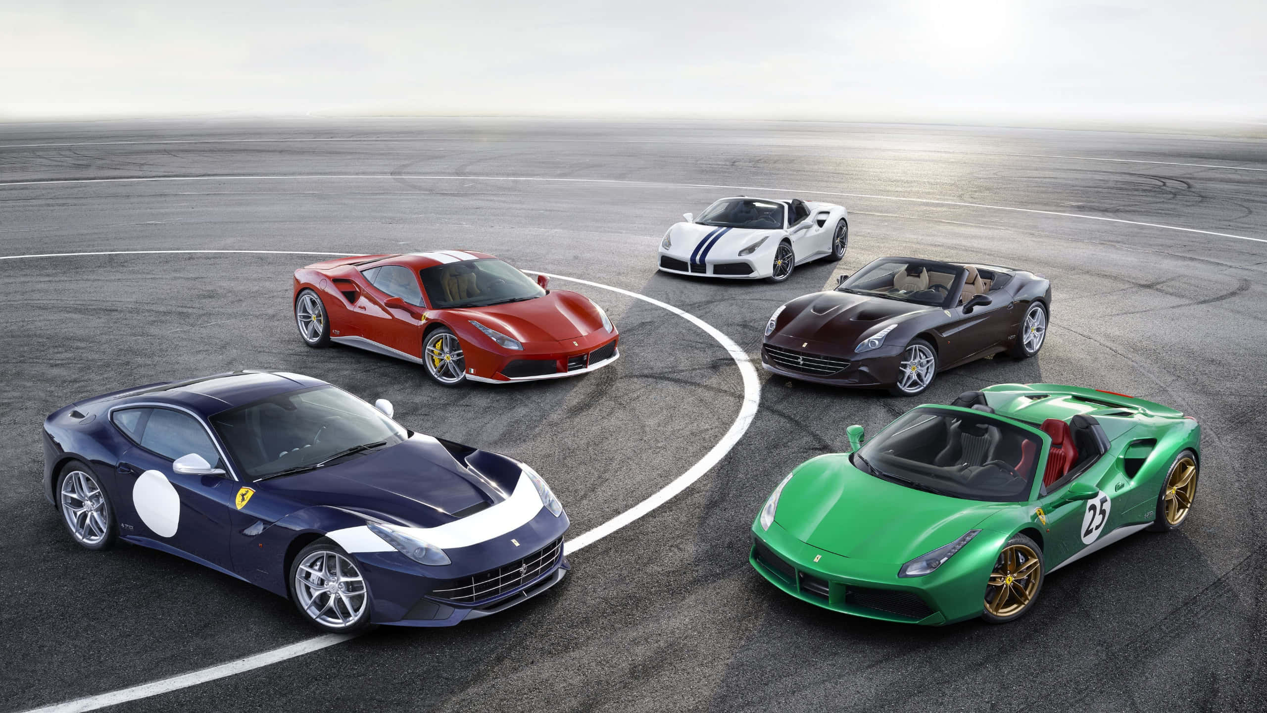 法拉利 桌布 壁紙 — 五輛鮮豔的 Ferrari 跑車在陰天賽道上排列成一個圓圈。