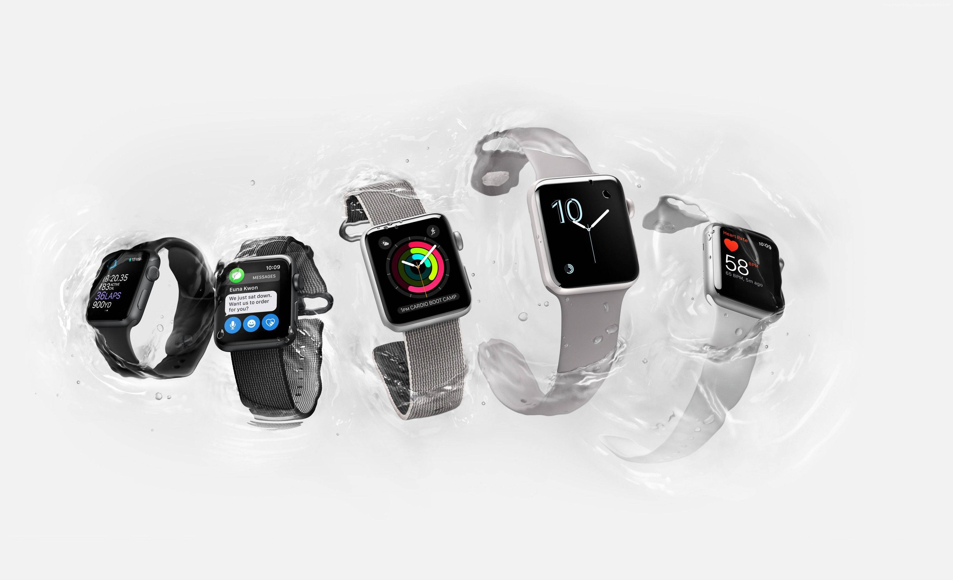 Apple Watch 動態 桌布 壁紙 — 五隻Apple Watch漂浮在清澈的水滴中，以潔白的背景展示不同的錶帶和錶面。