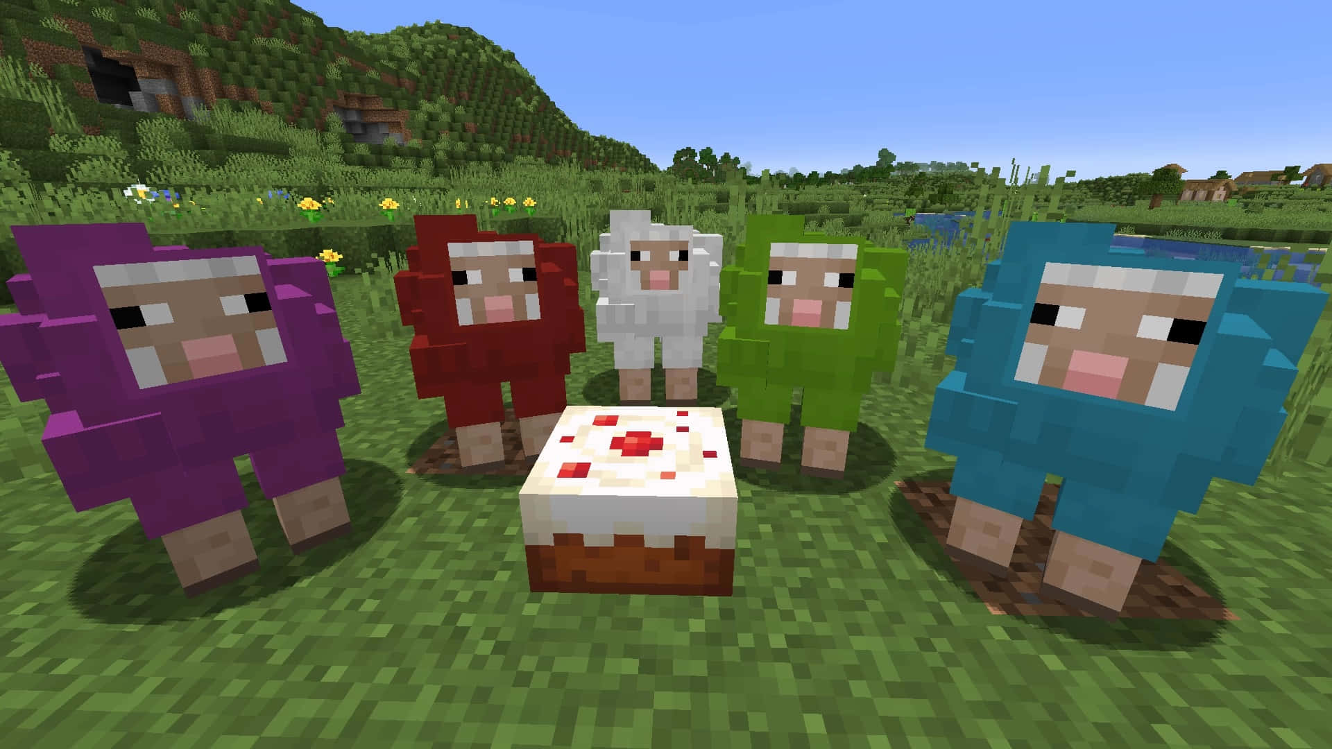 Minecraft Sheep 桌布 壁紙 — 五隻像素化的Minecraft羊，身上有彩色羊毛，站在一個蛋糕周圍，在一片草地上，天空晴朗蔚藍。