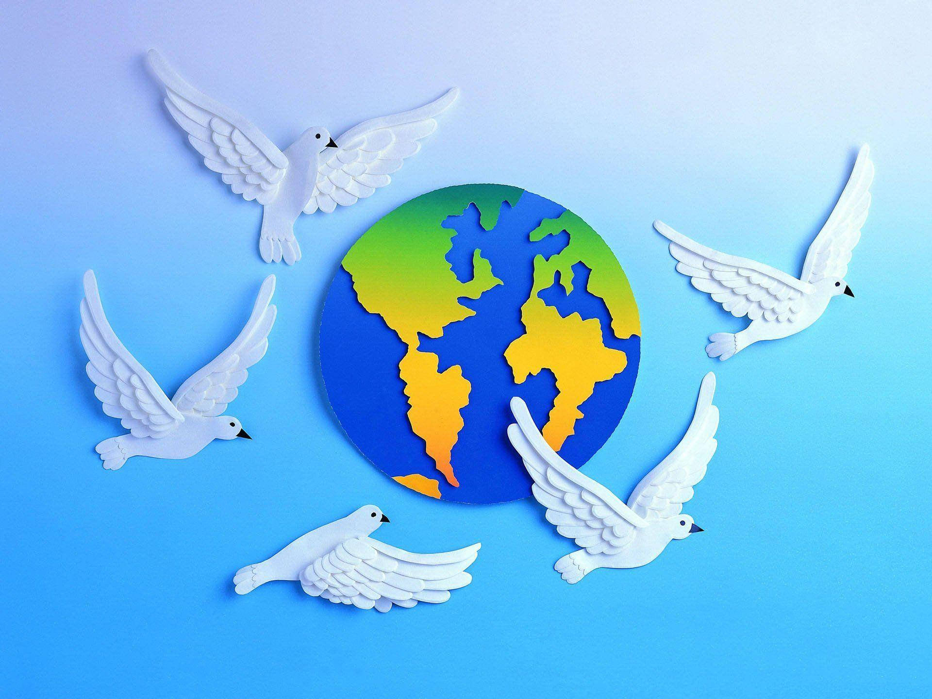 World 桌布 壁紙 — 五隻白色鴿子剪紙在柔和的藍色漸變背景前圍繞一個彩色紙地球儀翱翔。