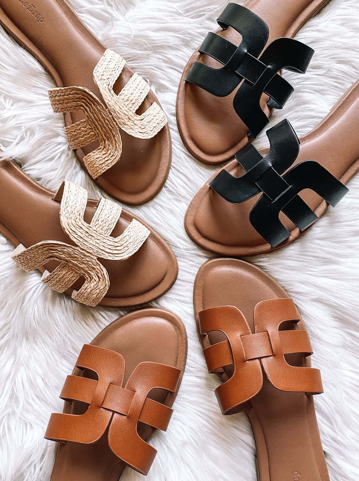 Sandals 桌布 壁紙 — 五雙愛馬仕風格涼鞋，採用棕褐色、黑色和棕色皮革及編織帶，排列在蓬鬆的白色地毯上。