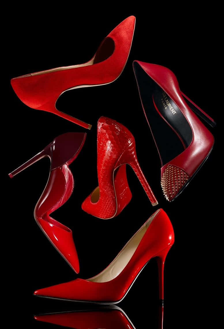 Red High Heels 桌布 壁紙 — 五雙華麗的紅色高跟鞋在純黑色背景上動態漂浮，帶有光澤反射。