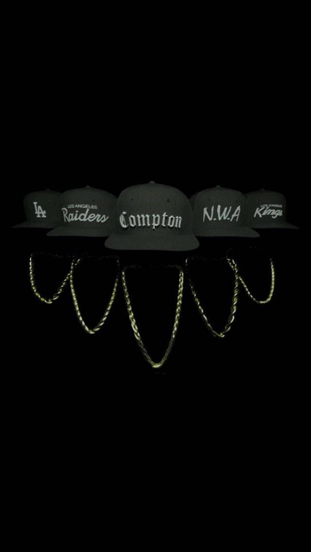Gangsta 桌布 壁紙 — 五頂深綠色 snapback 帽子，帶有 LA 運動和嘻哈標誌，在黑色背景下發光，下方有反光金色鏈條。