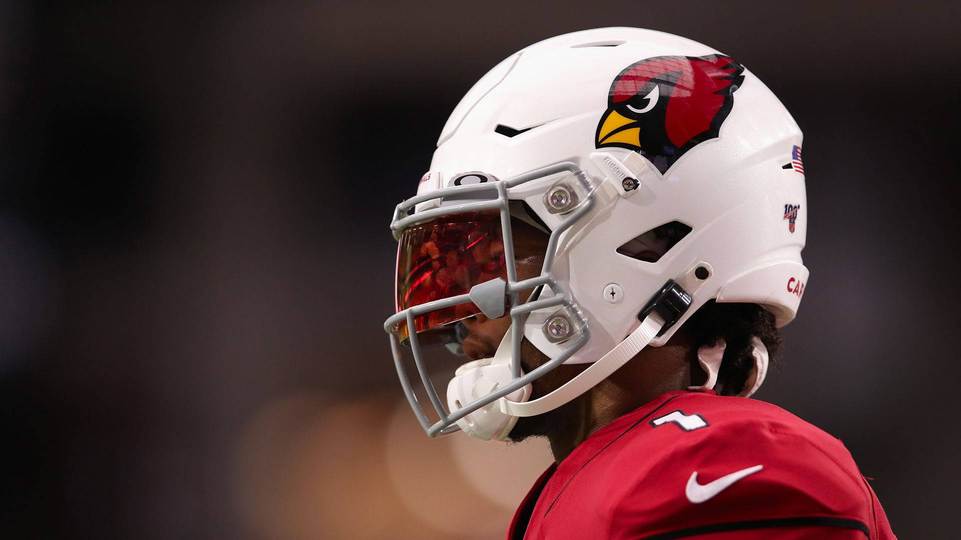 Arizona Cardinals 桌布 壁紙 — 亞利桑那紅雀隊美式足球員身穿白色頭盔和紅色球衣，在比賽期間望向鏡頭外的特寫。