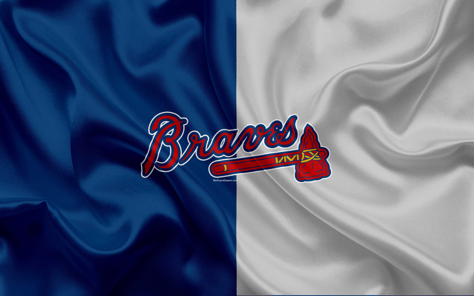 Braves 桌布 壁紙 — 亞特蘭大勇士隊標誌居中，背景為分裂的藍白緞面布料，帶有流動的褶皺。