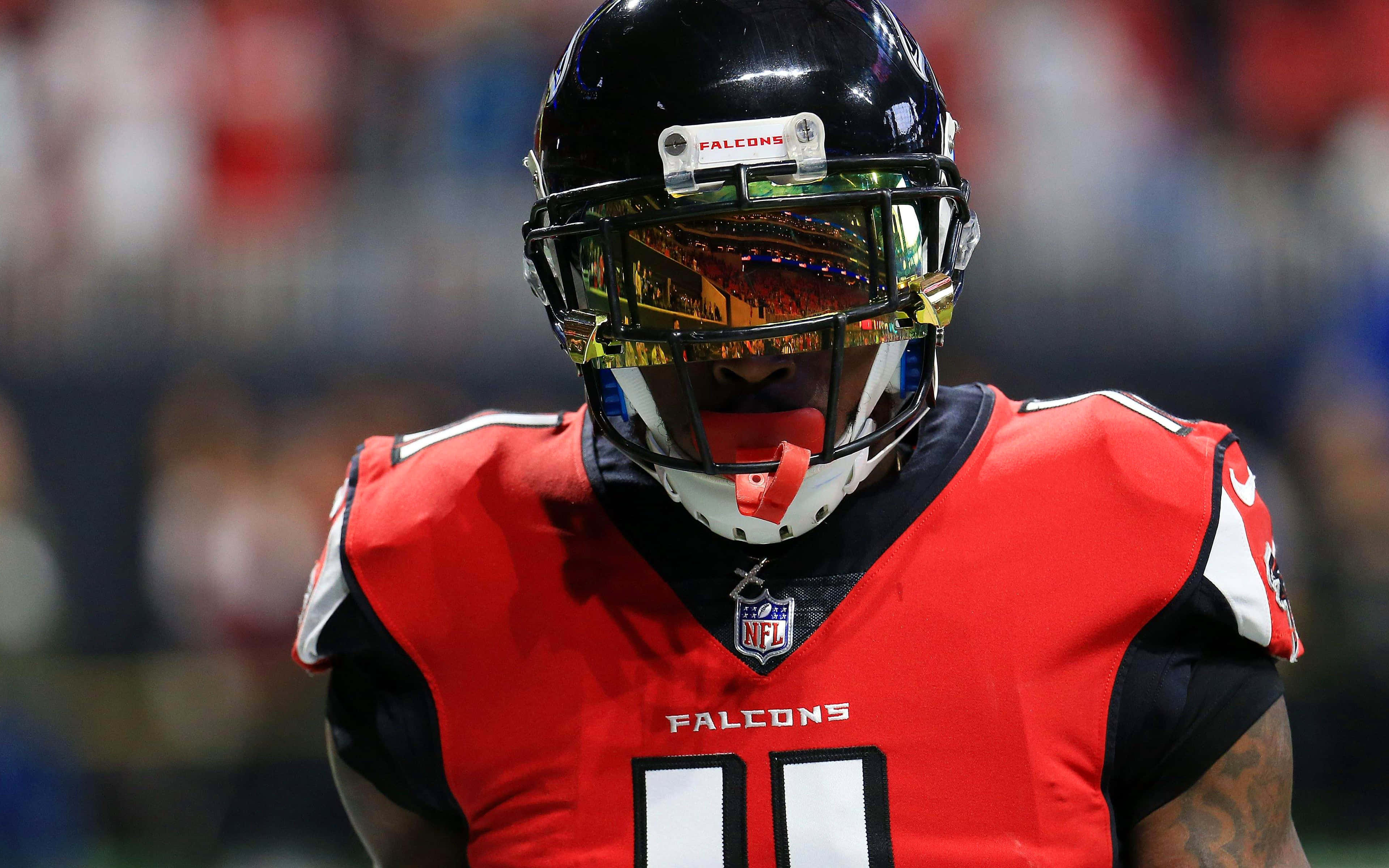 Julio Jones 桌布 壁紙 — 亞特蘭大獵鷹美式足球員在比賽中的特寫，身穿紅色球衣和黑色頭盔，配有反光面罩。