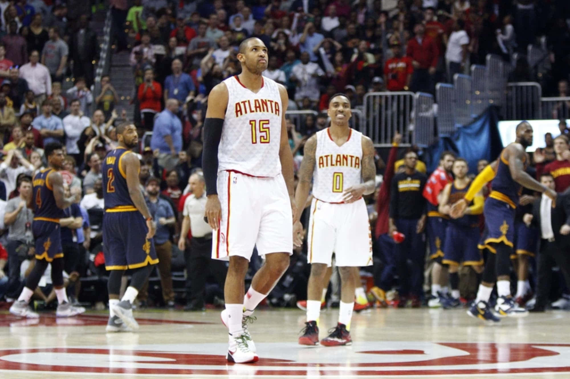 Al Horford 桌布 壁紙 — 亞特蘭大老鷹隊球員身穿白色球衣，在比賽期間站在籃球場上，背景是擠滿的人群。