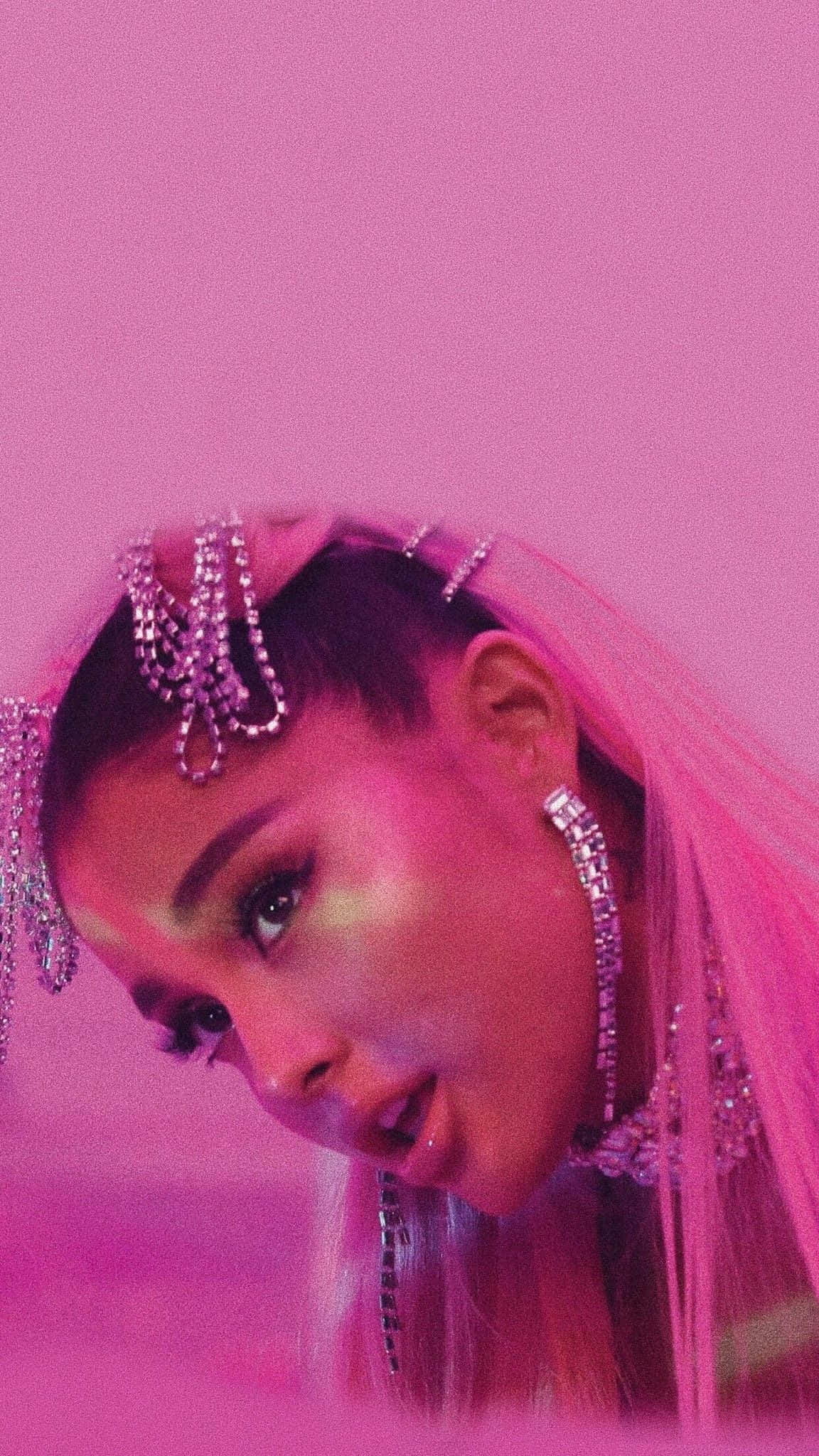 Ariana Grande 7 Rings 桌布 壁紙 — 亞莉安娜·格蘭德（Ariana Grande）在單色粉紅背景下，佩戴閃爍的鑽石头飾和粉紅面紗，凝視著鏡頭。