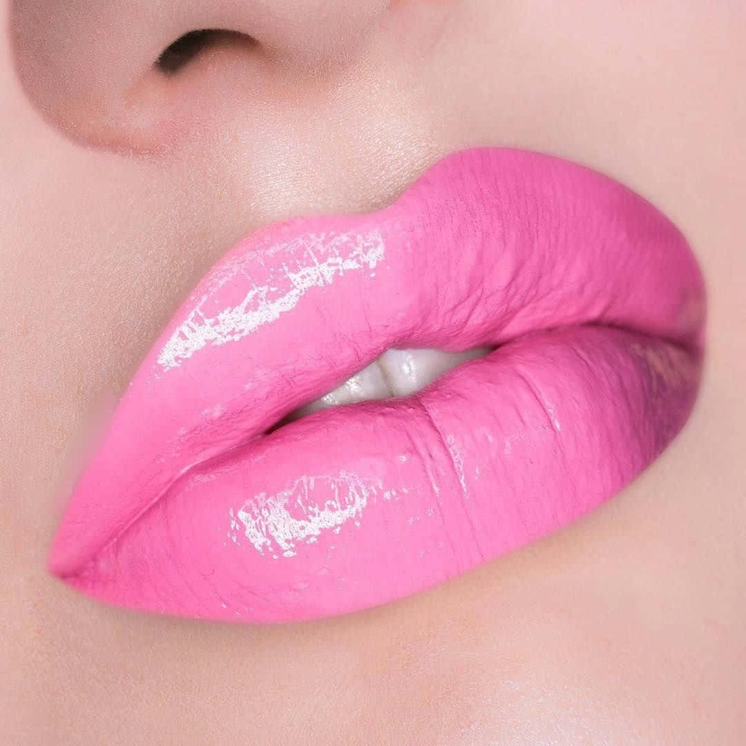 Pink Lipstick 桌布 壁紙 — 亮粉紅色嘴唇的特寫，帶有白色亮粉點綴和可見的自然肌膚紋理。