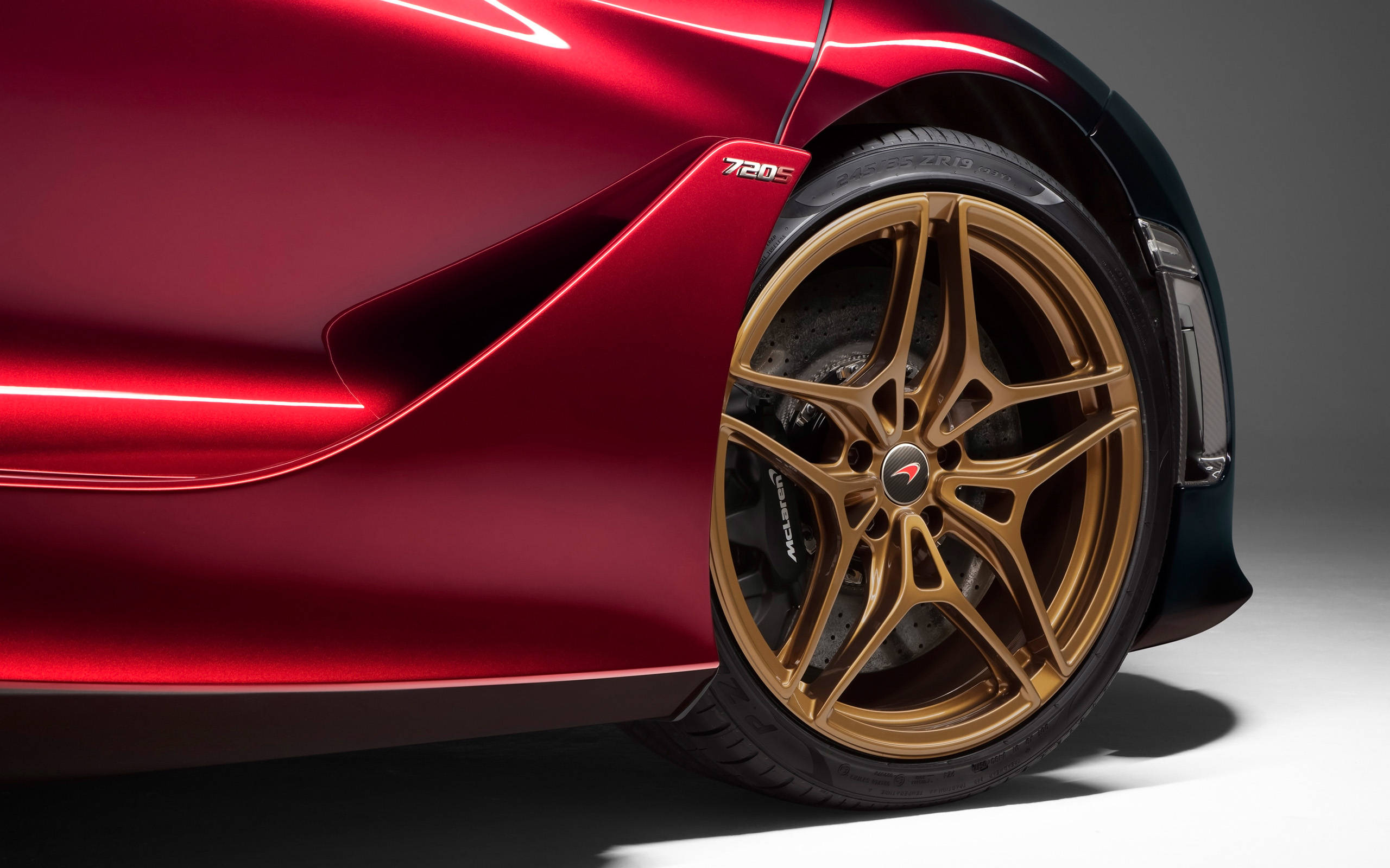 mclaren 720s 4K 桌布 壁紙 — 亮紅色McLaren 720S跑車的特寫，突出其金色合金輪圈和空氣動力學車身。