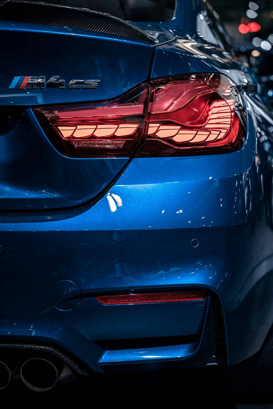 桌布 壁紙 — 亮藍色BMW M4 CS跑車尾部的特寫，帶有發光的紅色尾燈和碳纖維飾件。