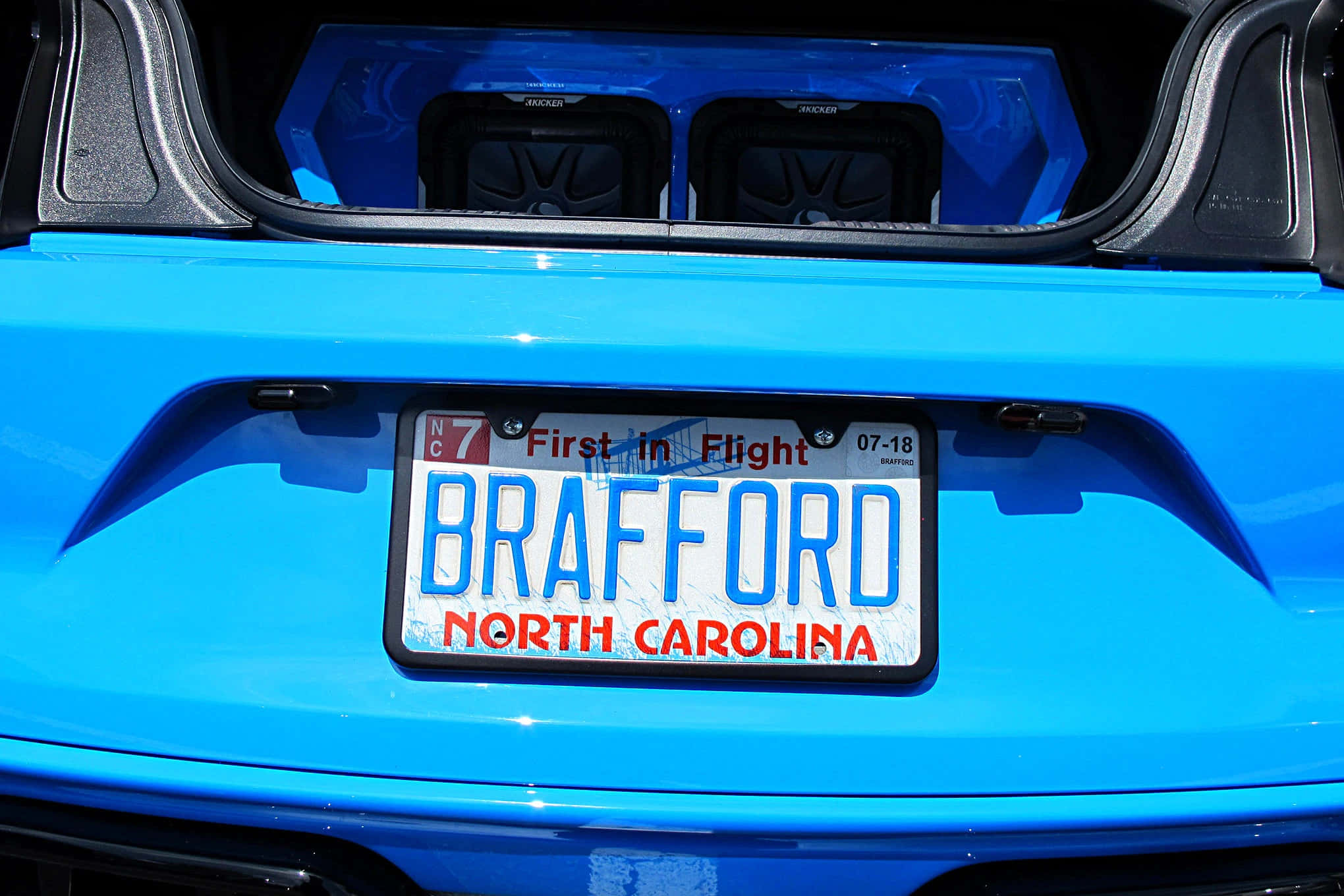 License Plate 桌布 壁紙 — 亮藍色汽車後部的特寫，顯示帶有「BRAFFORD」和「First in Flight」標語的北卡羅來納州車牌。