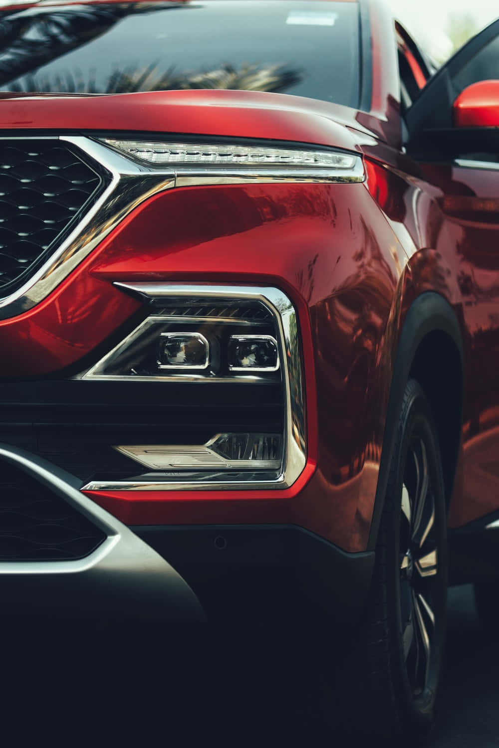 Mg 桌布 壁紙 — 亮面紅色SUV車頭近距離特寫，在明亮日光下展現時尚頭燈與鍍鉻飾件。
