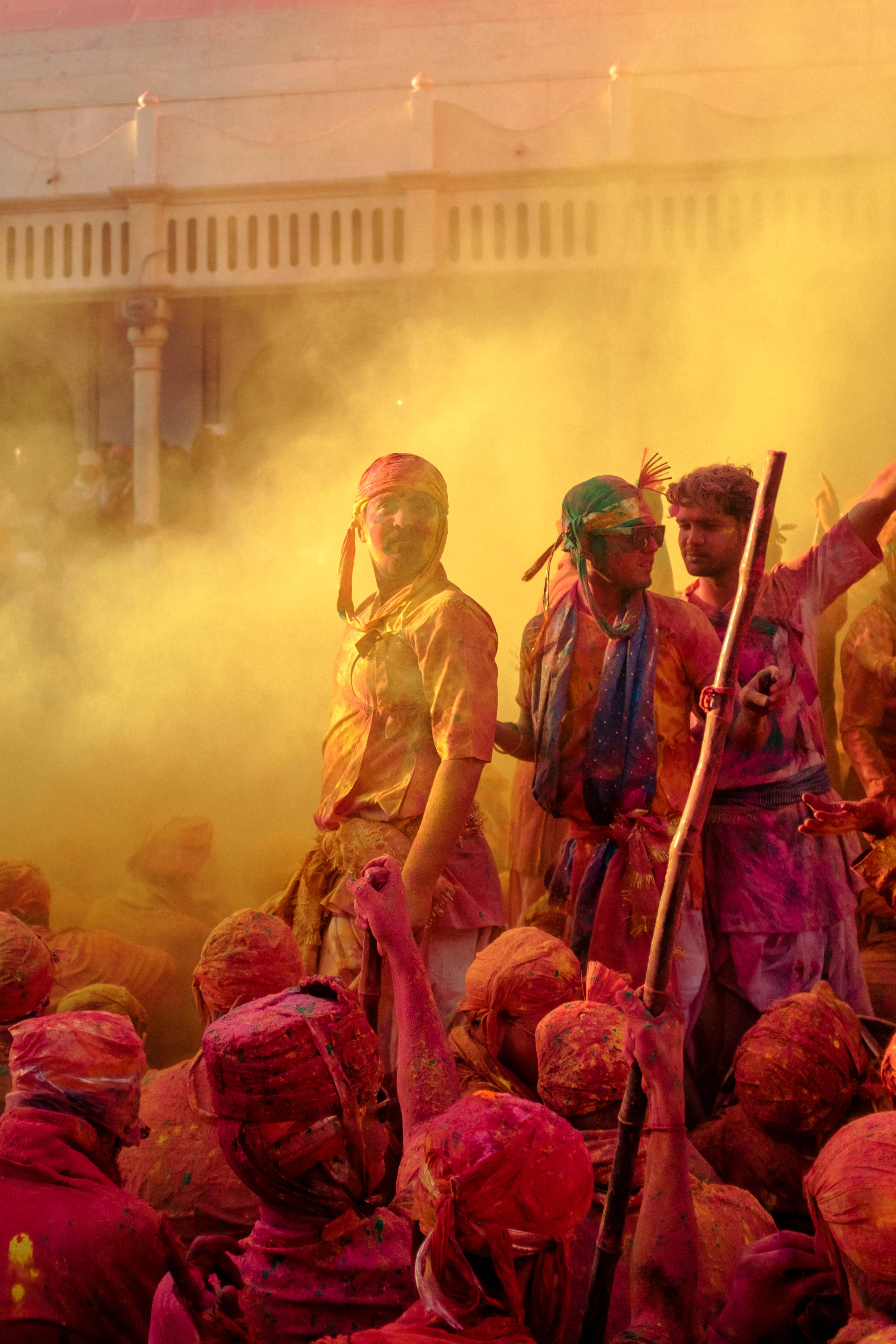 Holi 桌布 壁紙 — 人們在寺廟建築周圍用鮮豔的彩色粉末和煙霧慶祝灑紅節。