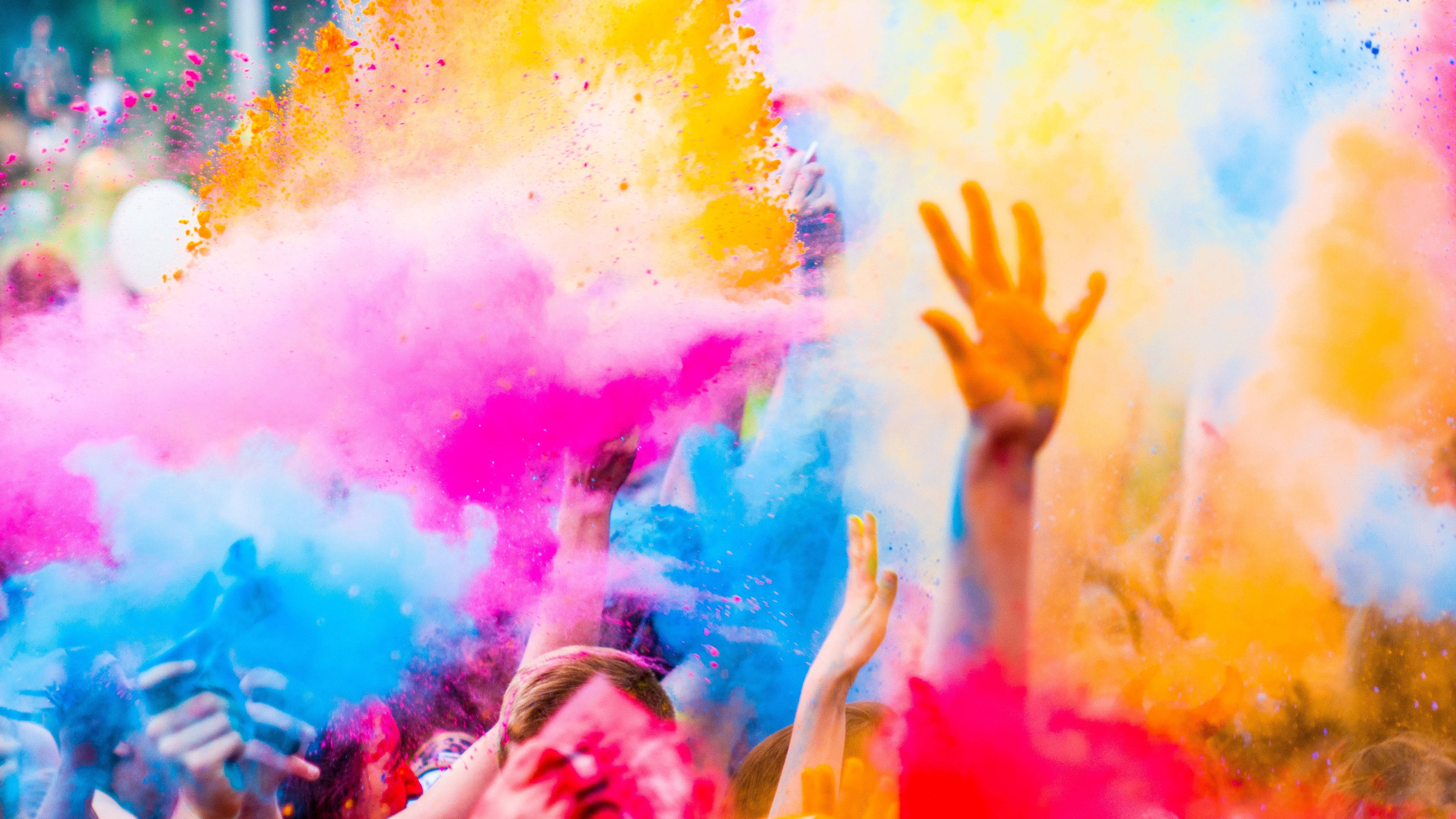 color full HD 桌布 壁紙 — 人們在節日慶祝活動中歡樂地將鮮豔的彩色粉末拋向空中。
