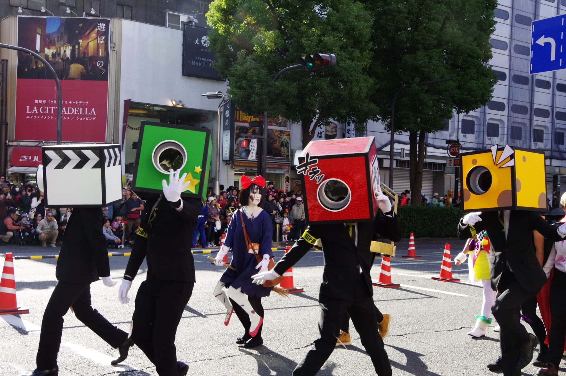 Halloween Parades 桌布 壁紙 — 人們穿著色彩繽紛的盒子服裝，在熱鬧的遊行中沿著繁忙的東京街道行進。