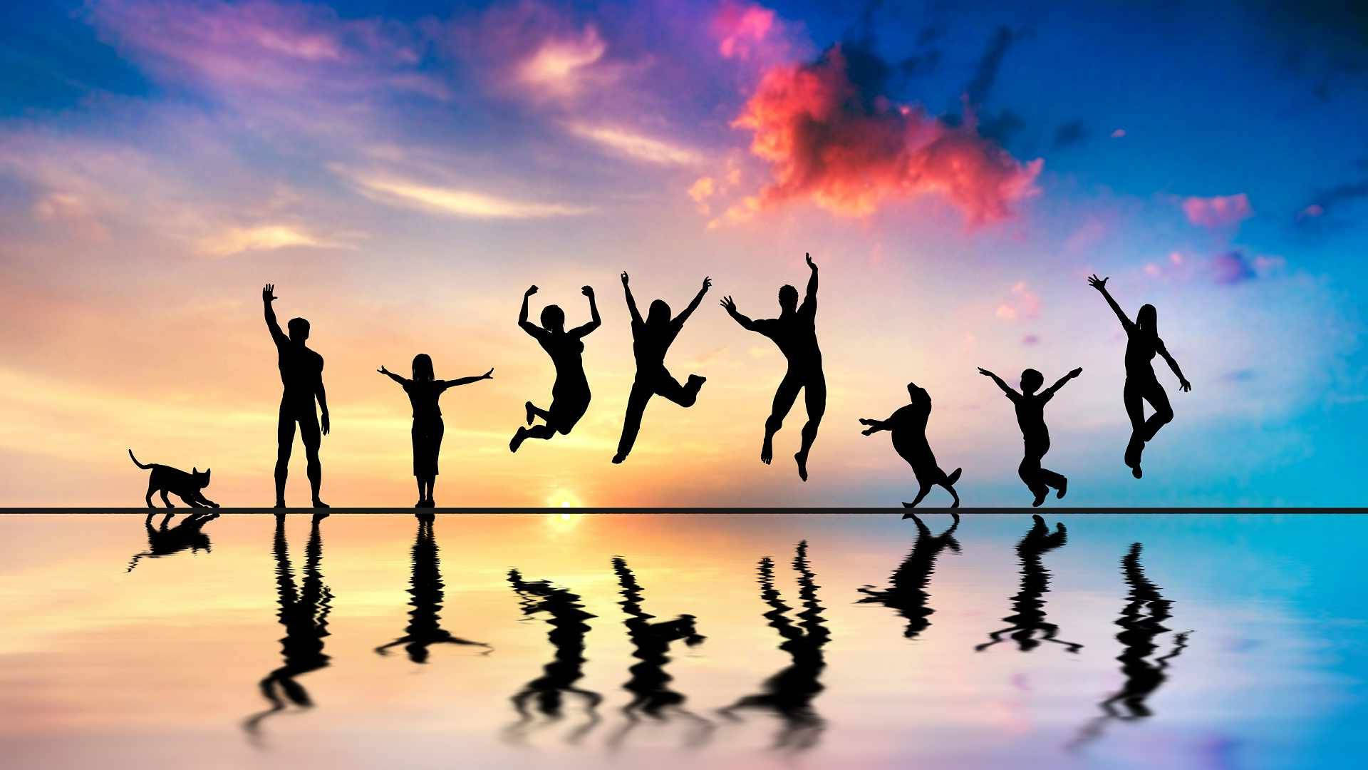 group 桌布 壁紙 — 人物和一隻狗的剪影，在平靜水面映照的鮮豔日落天空下歡樂跳躍。