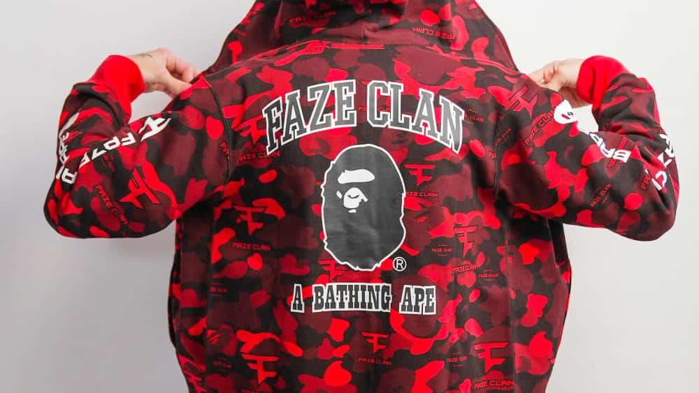 Bape 動態 桌布 壁紙 — 人物展示一件紅黑迷彩連帽上衣，上面有醒目的 FAZE CLAN 和 A BATHING APE 標誌。
