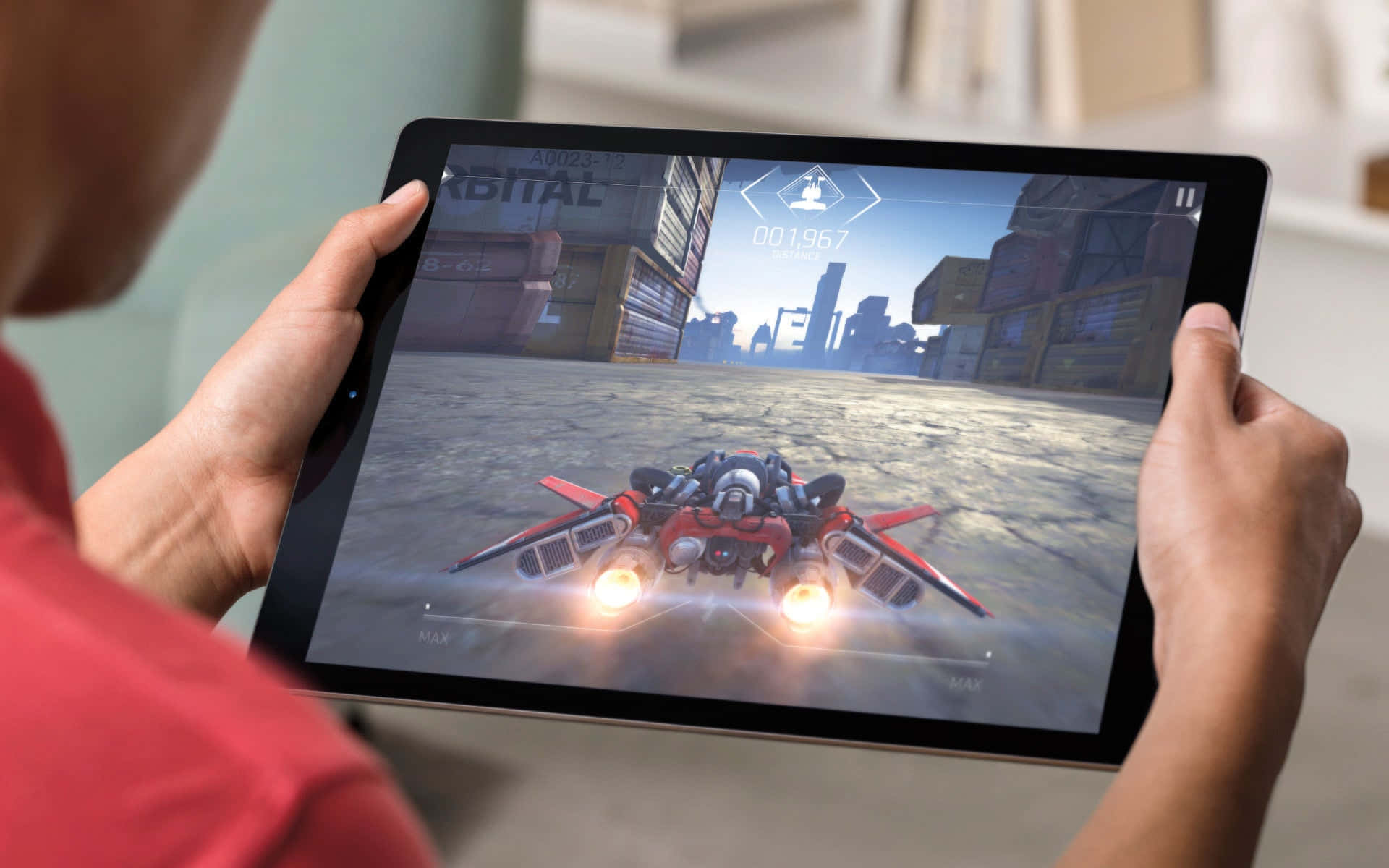 iPad 桌布 壁紙 — 人物手持平板電腦，在城市賽道上玩著一款以紅色噴射動力車輛為特色的未來主義賽車遊戲。