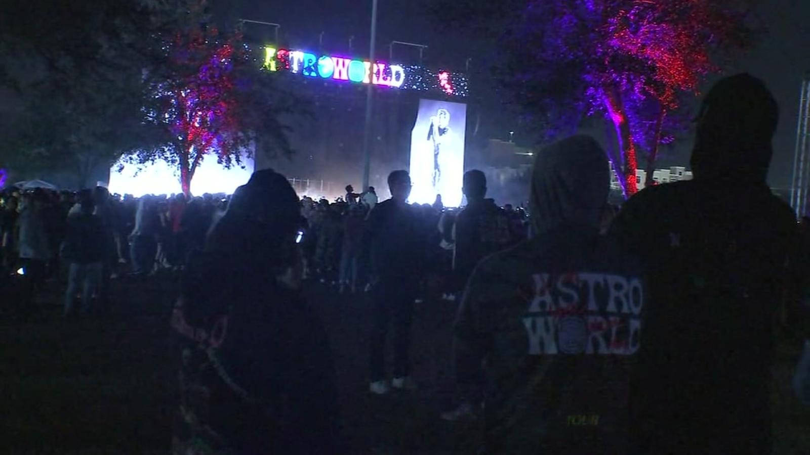 Travis Scott Astroworld 桌布 壁紙 — 人群在夜晚聚集在發光的AstroWorld標誌下，樹木和大螢幕上閃爍著五彩燈光。