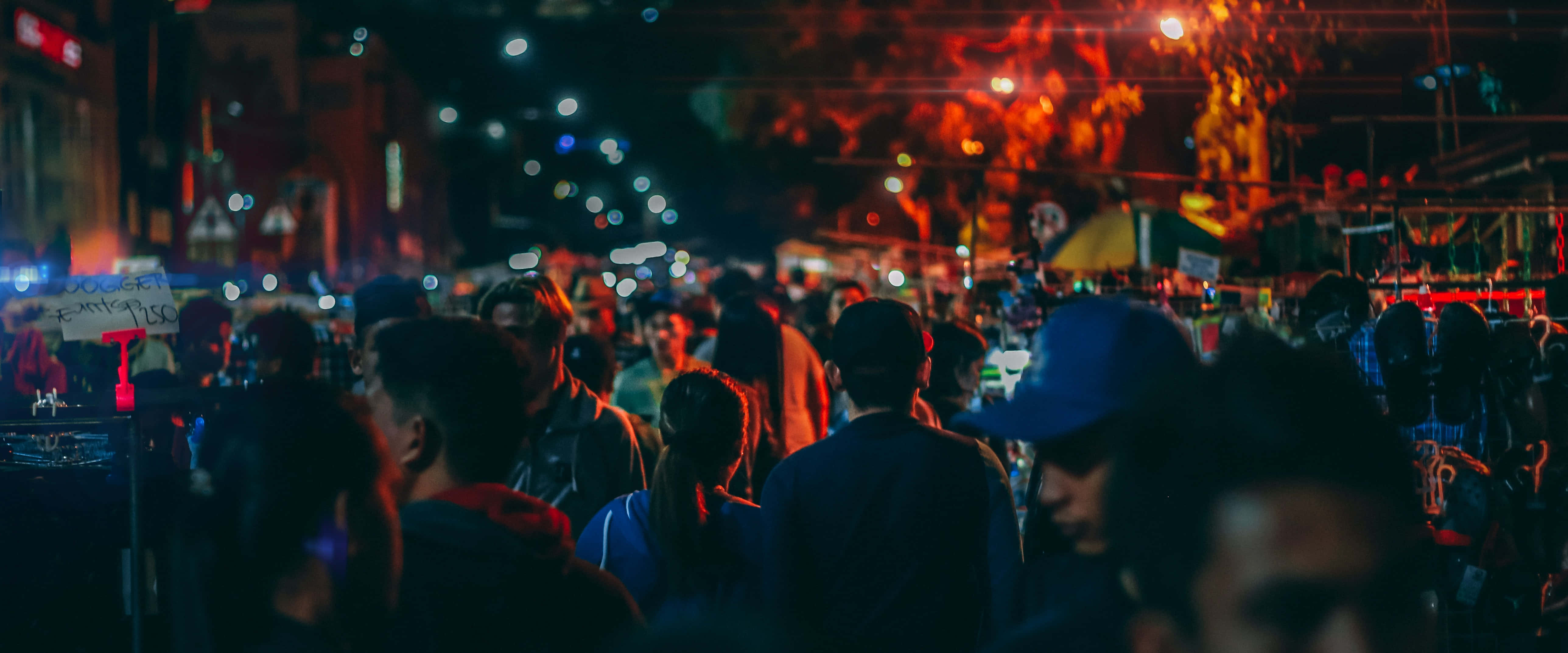 人物 桌布 壁紙 — 人群穿過充滿活力的夜市，燈光閃爍，散發溫暖的散景效果。