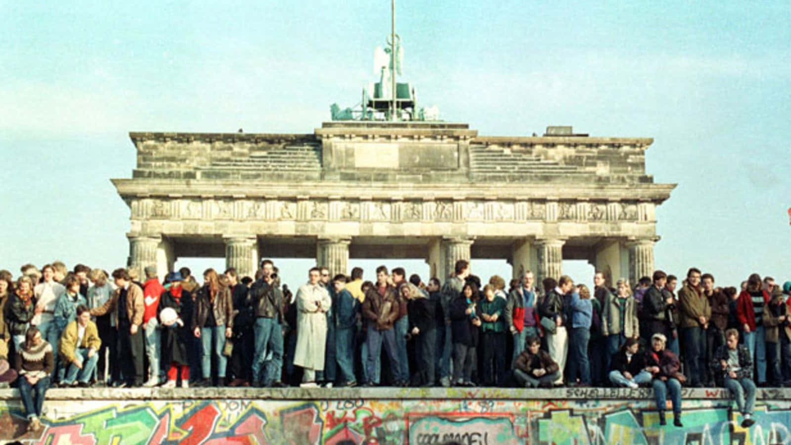 wall 桌布 壁紙 — 人群站在布蘭登堡門附近的柏林圍牆頂上，天空清澈湛藍。