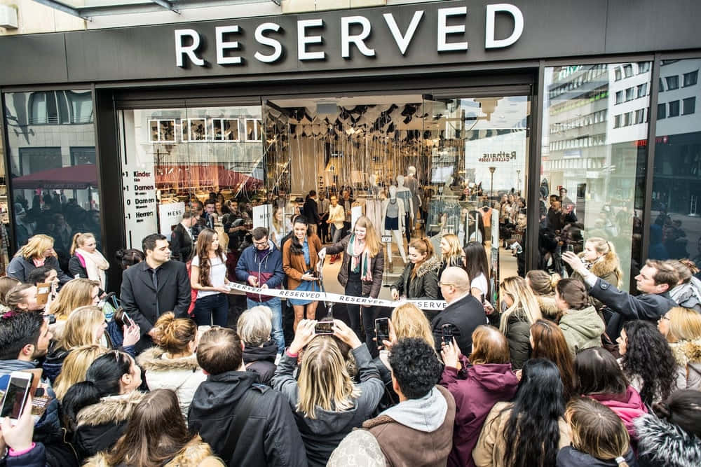 高清 桌布 壁紙 — 人群聚集在Reserved商店外，人們剪綵慶祝盛大開業。