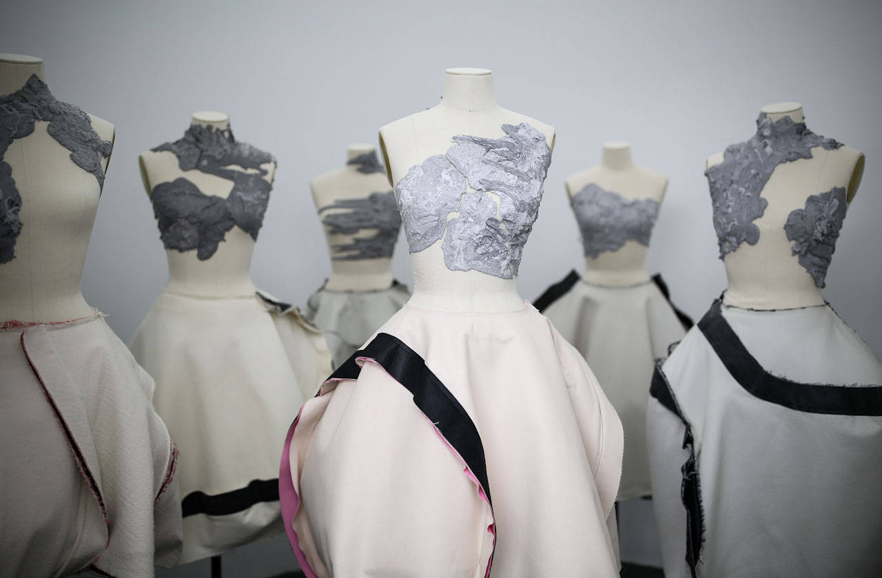 mannequin 桌布 壁紙 — 人體模型展示前衛連衣裙，採用質感灰色緊身胸衣和流暢的奶油色裙子，並以黑色和粉紅色飾邊點綴。