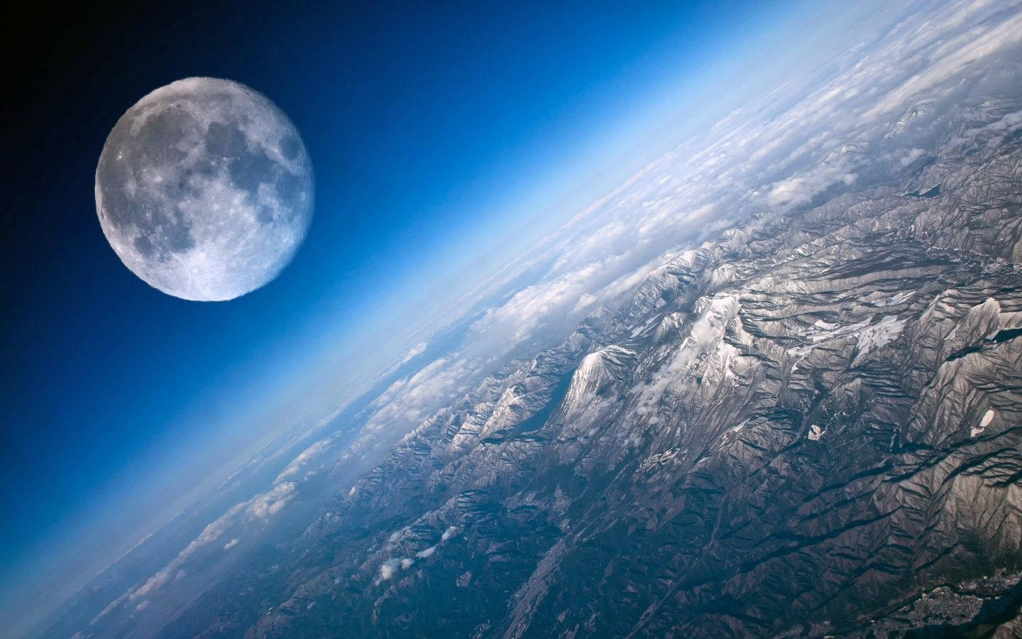 地球 桌布 壁紙 — 令人嘆為觀止的地球彎曲地平線景觀，下方有積雪的山脈和雲層，以及深空中的滿月。