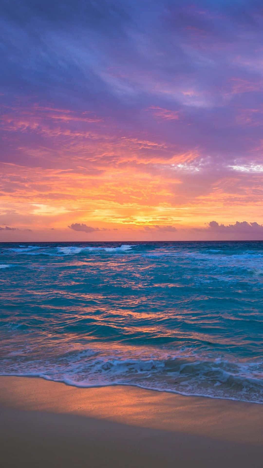 Pretty Ocean 桌布 壁紙 — 令人嘆為觀止的夕陽將海洋染成火熱的橙色和紫色色調，海浪輕輕拍打沙灘。