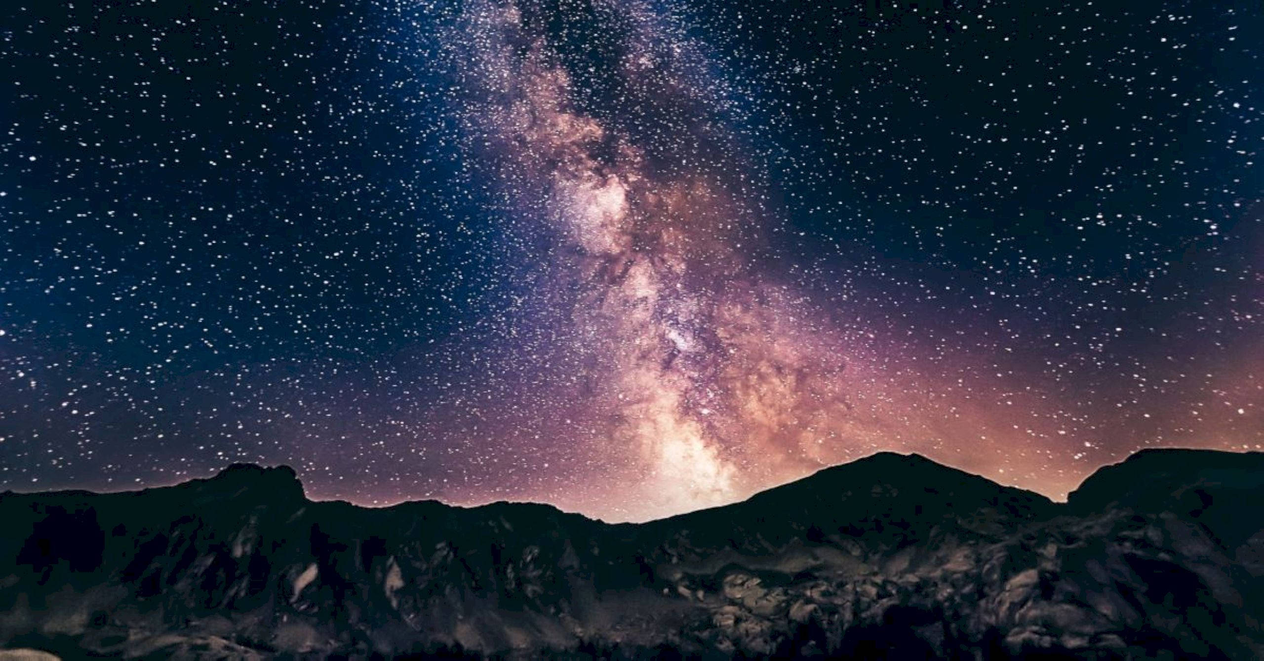 山脈 桌布 壁紙 — 令人嘆為觀止的夜空，佈滿無數星星，閃爍的銀河在黑暗的山峰剪影上方拱起。