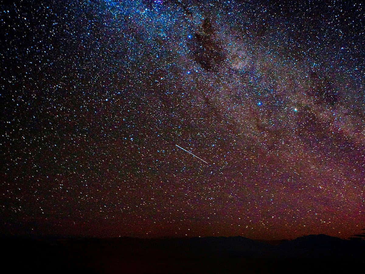 夜空 桌布 壁紙 — 令人嘆為觀止的夜空，充滿無數星星和銀河拱在頭頂，一顆流星劃過天際。