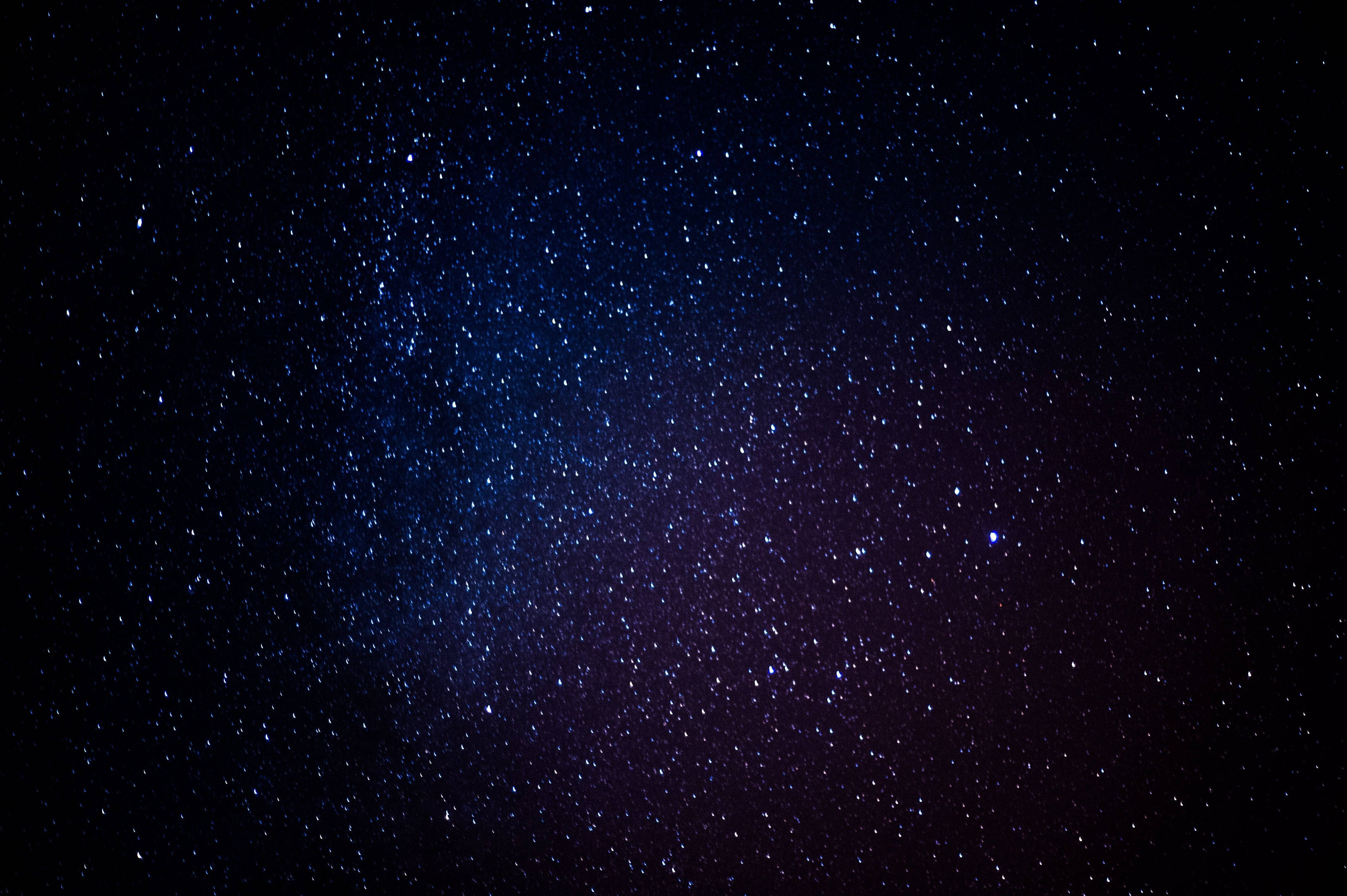 夜空 桌布 壁紙 — 令人嘆為觀止的夜空，充滿無數閃爍的星星，呈現深藍和紫色調，映襯著黑暗的宇宙背景。