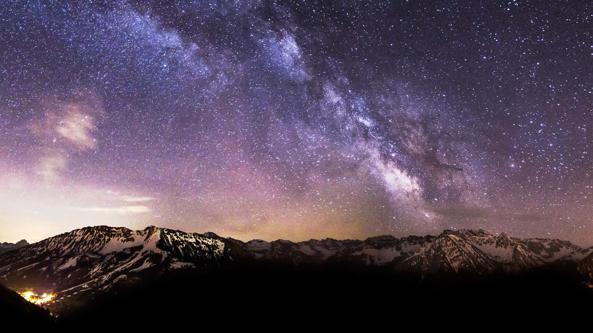 星星動圖 桌布 壁紙 — 令人嘆為觀止的夜空佈滿星星，銀河在積雪的山峰上拱起，地平線閃耀著光芒。