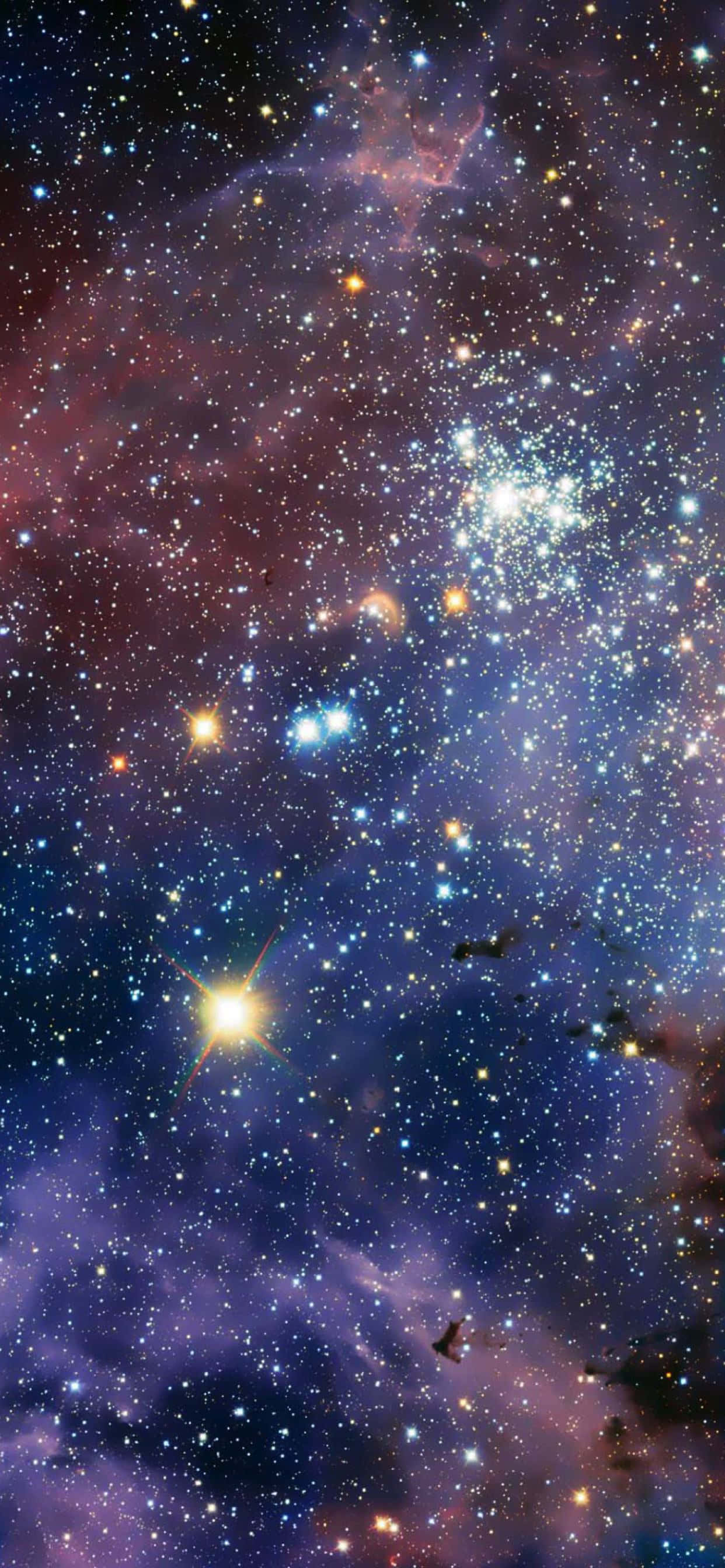外太空 桌布 壁紙 — 令人嘆為觀止的宇宙星雲景觀，充滿了發光的恆星和旋轉的紫色、粉紅色和藍色氣體雲。