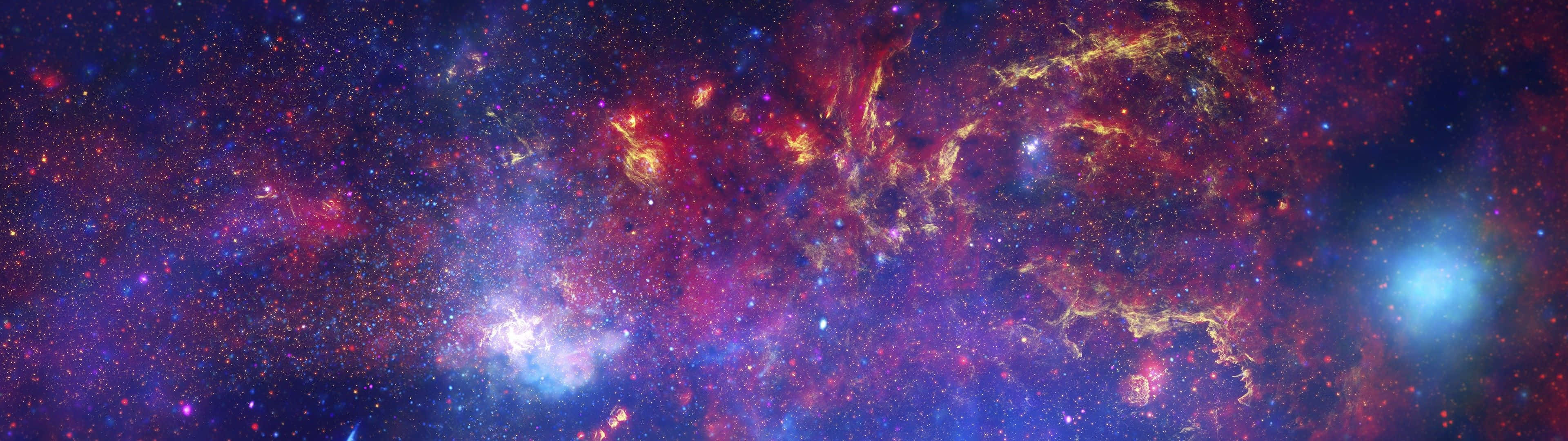 桌布 壁紙 — 令人嘆為觀止的宇宙景觀，呈現出紫色、紅色和藍色鮮豔色調中發光的星雲和旋轉的星場。