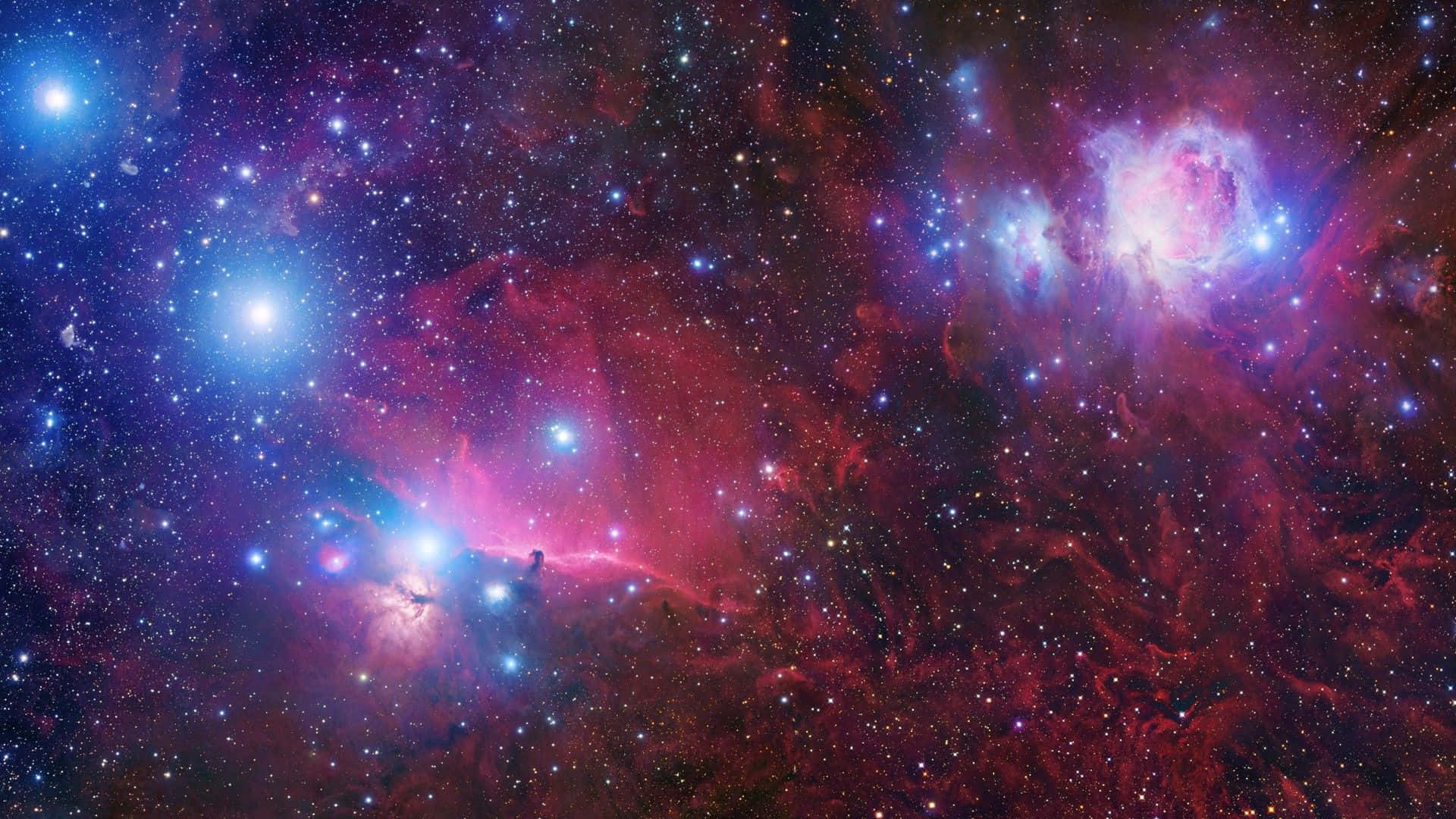 外太空 桌布 壁紙 — 令人嘆為觀止的宇宙景象，發光的粉紅色和藍色星雲在深邃的太空背景下與無數星星旋轉交織。
