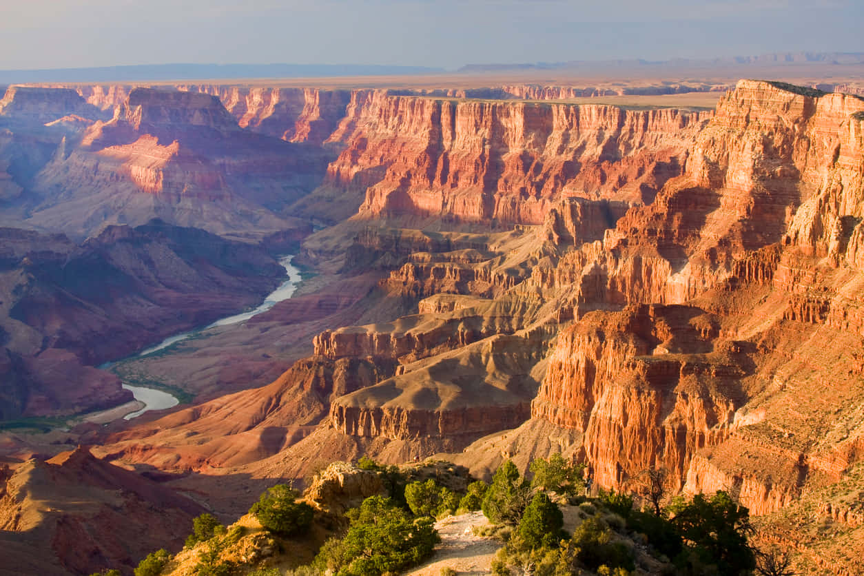 grand canyon 桌布 壁紙 — 令人嘆為觀止的日出照亮了大峽谷層層疊疊的紅色懸崖和蜿蜒的河流。