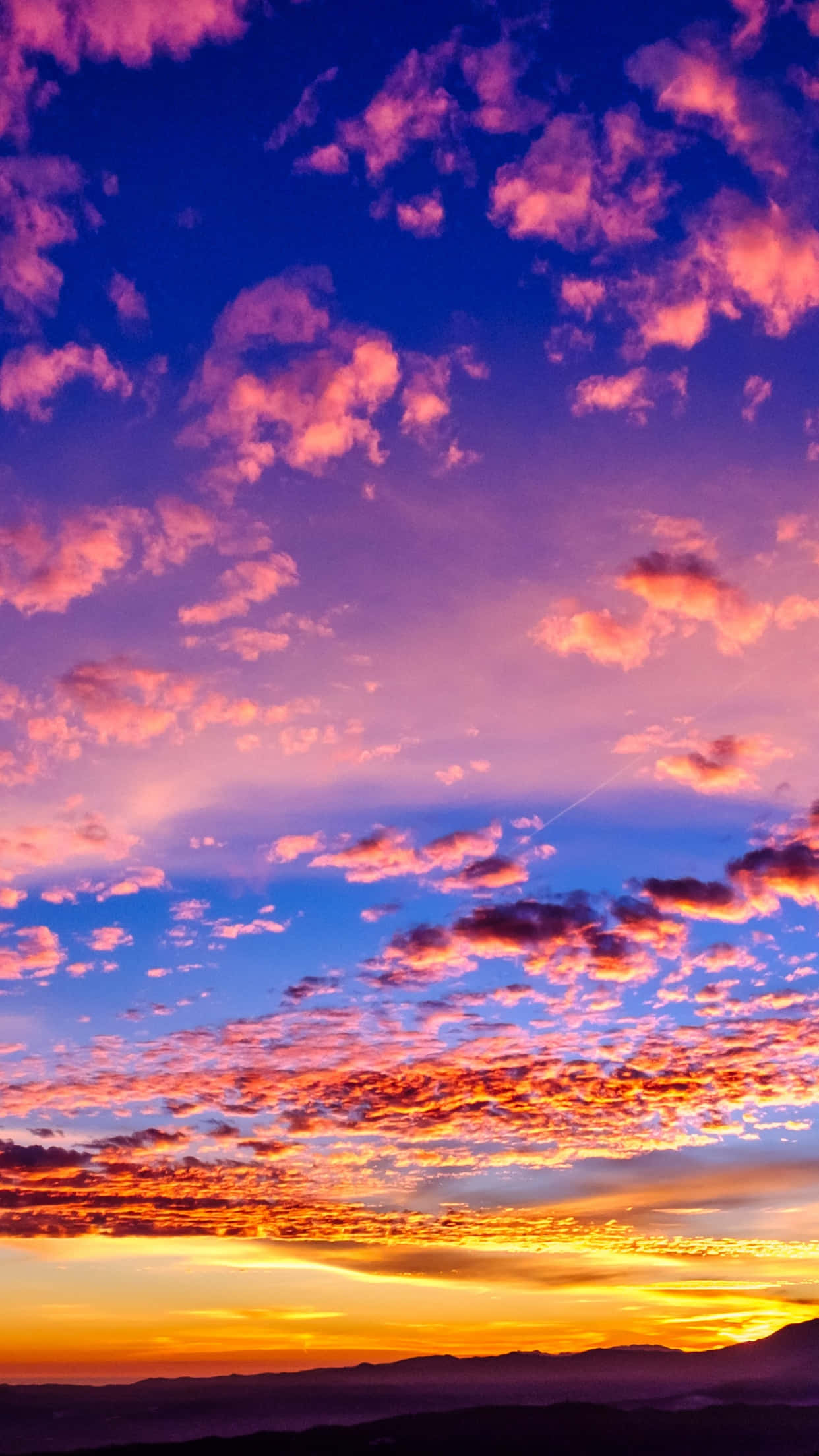 Clouds Aesthetics 桌布 壁紙 — 令人嘆為觀止的日落，在遠山之上的深藍色畫布上，描繪出火紅的橙色和粉紅色的雲彩。