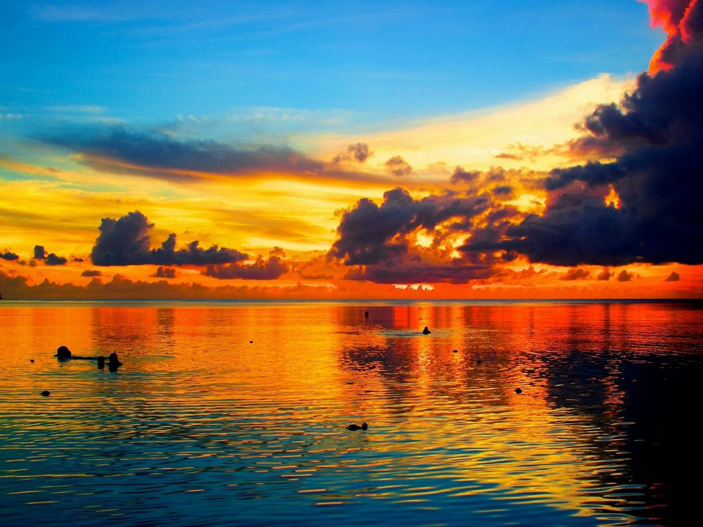 Guam 桌布 壁紙 — 令人嘆為觀止的日落，平靜的海面上，火紅的橙色和藍色天空倒映在漣漪中。